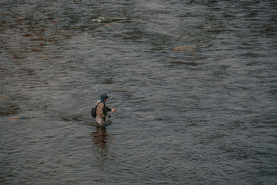 Photo of a man fly fishing in a river